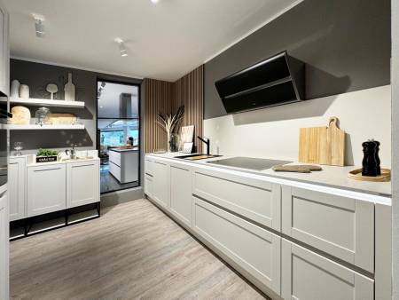 Zeitgenössische Küche mit weißen Schränken und grauer Arbeitsplatte, kombiniert mit dunklen Holzakzenten und offenen Regalen.