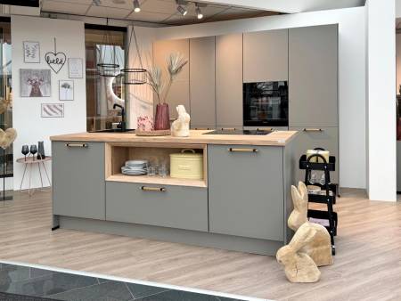 Helles, modernes Küchendesign mit grauen Schränken, Holzarbeitsplatte und dekorativen Elementen wie einer Hasenstatue und Wandkunst.